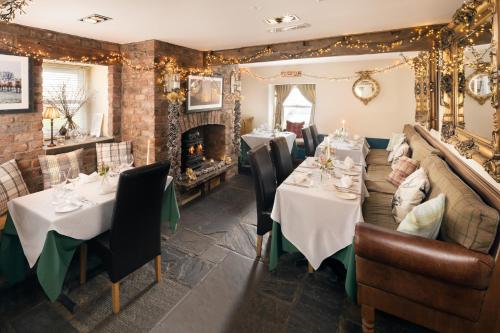 a restaurant with tables and chairs and a fireplace at Timble Inn in Timble