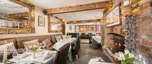 a restaurant with tables and chairs and a fireplace at Timble Inn in Timble