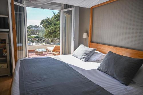 a bedroom with a large bed and a large window at La Lune De Mougins - Hotel & Spa in Mougins