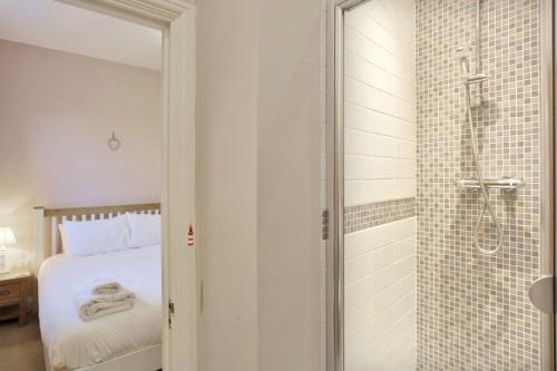 a bedroom with a bed and a glass shower at Happy Days in Southwold