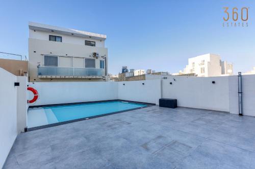 a swimming pool on the roof of a building at The Swieqi Poolside Suites in Is-Swieqi