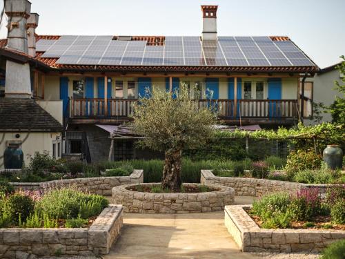 una casa con paneles solares en el techo en BIOHOTEL StDaniel en Štanjel