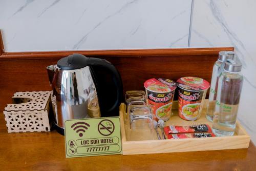 a wooden tray with a tea kettle and some food at Lộc Sơn Hotel in Buon Ma Thuot