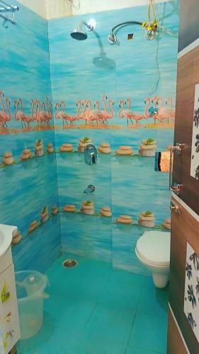 a bathroom with a shower with pink flamingos on the wall at Krishnabalram wellness & Ayurveda centre in Rishīkesh
