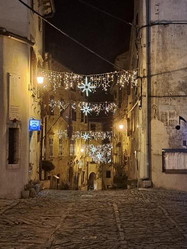 an alley with christmas lights in a city at night at Rooms Svalina in Grožnjan
