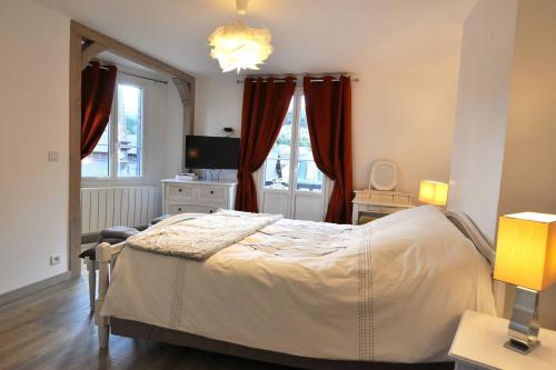 Cette chambre comprend un lit avec des rideaux rouges et une télévision. dans l'établissement La terrasse, à Étretat