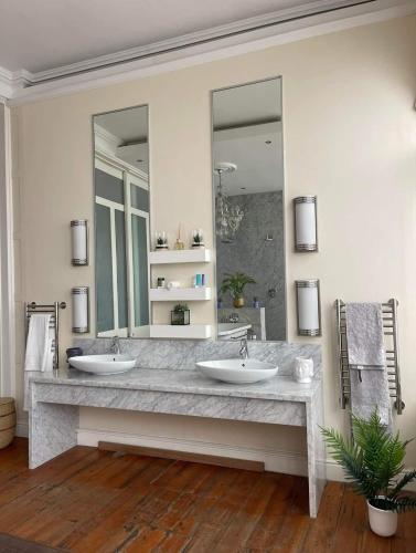 a bathroom with two sinks and two mirrors at Ikhaya in Cape Town