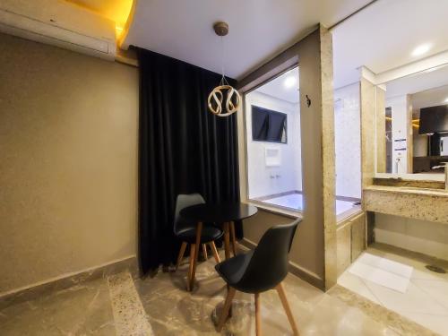 a dining room with a table and chairs and a window at Lina Motel Tatuapé in Sao Paulo