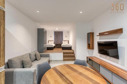 a living room with a couch and a table at The Swieqi Poolside Suites in Is-Swieqi