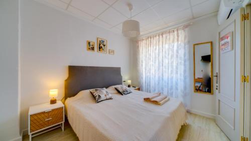 a bedroom with a large white bed with a window at Estudio SOL en Alicante in Alicante
