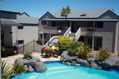 a swimming pool in front of a house at Baycrest Thermal Lodge in Taupo