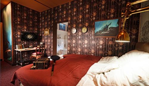 a bedroom with a large bed in a room with wallpaper at Weltraumbahnhof Rautenkranz - Steampunk Hotel in Muldenhammer
