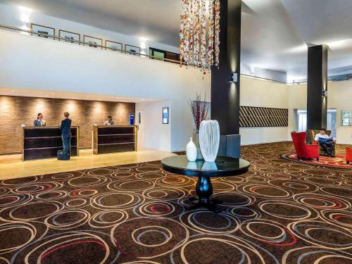 a lobby of a hotel with a table in the middle at Novotel Rotorua Lakeside in Rotorua