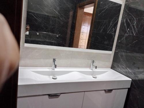 a bathroom with a white sink and a mirror at Villa Dar Nejib - Duplex de luxe 2S+4 à cité El Wafa in Nabeul