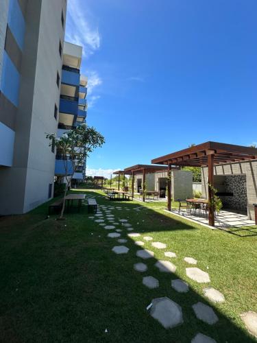 a walkway next to a building with a grass yard at Blue Beach Beira Mar in Cabedelo