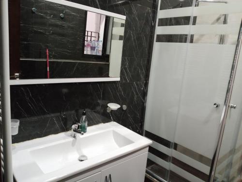 a bathroom with a sink and a shower and a mirror at Villa Dar Nejib - Duplex haut standing - cité El Wafa in Nabeul