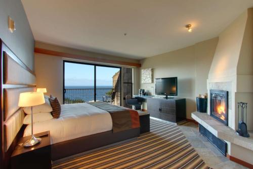 a bedroom with a large bed and a fireplace at Hyatt Carmel Highlands in Carmel