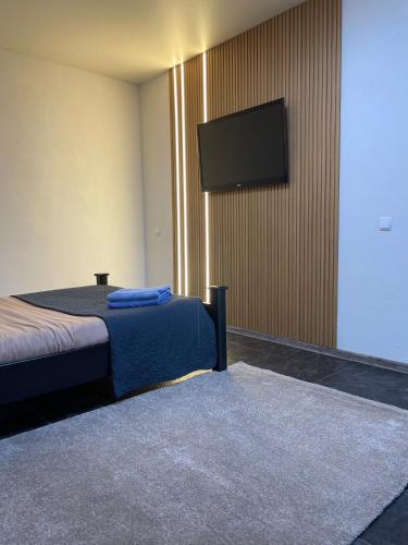 Schlafzimmer mit einem Bett und einem Flachbild-TV in der Unterkunft Квартира Сапфір Avenue Myru 35a in Tschernihiw