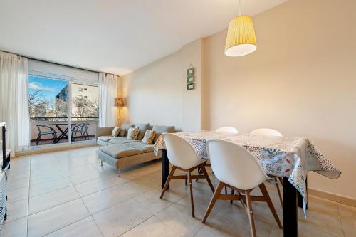 ein Wohnzimmer mit einem Tisch und einem Sofa in der Unterkunft Hauzify I Apartament Balmanya 2A in Sant Feliu de Guixols