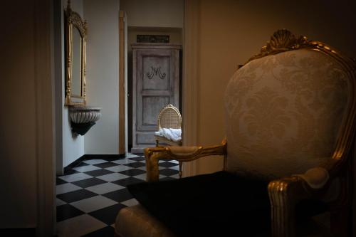 a room with a chair and a door with a checkered floor at San Giorgio Rooms in Genova