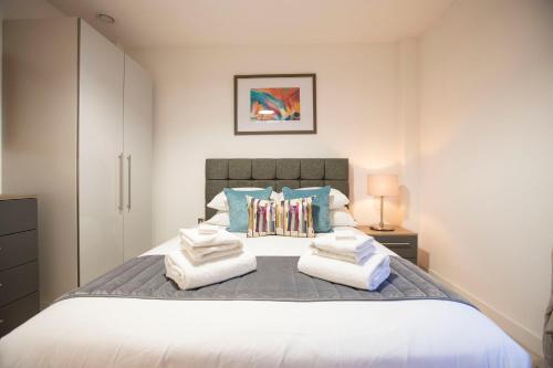 a bedroom with a large bed with towels on it at Urban Living's - King Edward Luxury Suites in Windsor