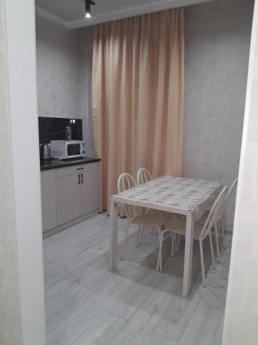 a kitchen with a table and chairs in a room at Алпамыс in Prigorodnyy