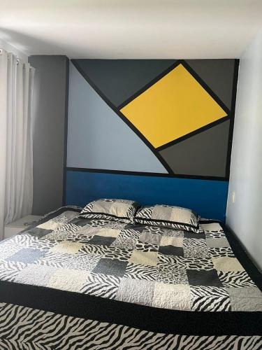 a bedroom with a bed with a painting on the wall at Praia de Itaparica com Vista para o Mar in Vila Velha