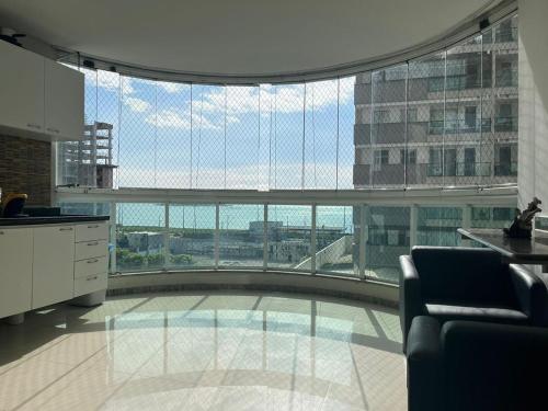 a large room with a large glass window in a building at Praia de Itaparica com Vista para o Mar in Vila Velha