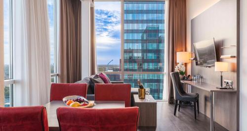 a hotel room with a table and chairs and a large window at Best Western Plus Plaza Almere in Almere