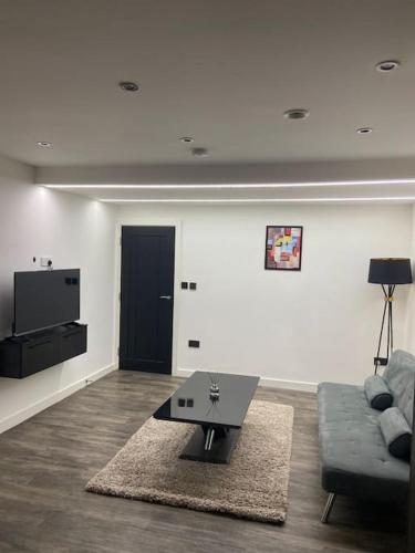 a living room with a couch and a table at Entire Apartment perfectly located for Heathrow Airport in Uxbridge