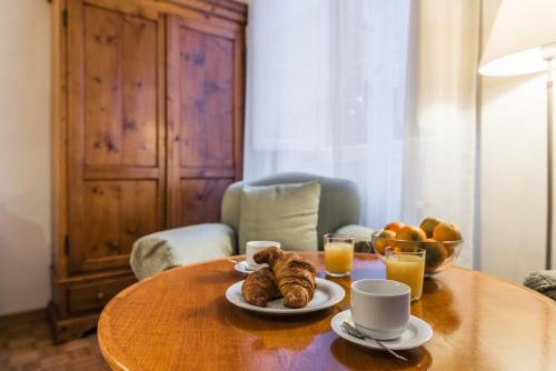 einen Tisch mit Croissants und Tassen Orangensaft in der Unterkunft XXseptemberHome in Rom