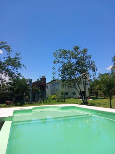 een leeg zwembad in een tuin met bomen bij Hostería La casa Bonita in Corrientes