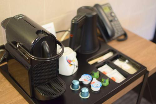 une cafetière assise au-dessus d'une table dans l'établissement Best Western Plus Le Conquerant Rouen Nord, à Bois-Guillaume