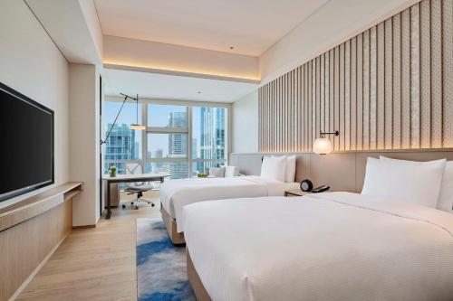 a hotel room with two beds and a flat screen tv at DoubleTree by Hilton Zhuhai Hengqin in Zhuhai