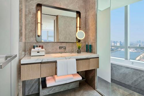 ein Bad mit einem Waschbecken und einem Spiegel in der Unterkunft DoubleTree by Hilton Zhuhai Hengqin in Zhuhai