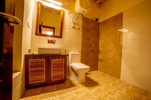 a bathroom with a toilet and a sink and a mirror at Royal Soma Resort in Stak