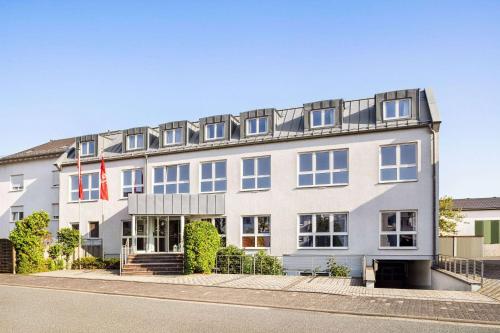 a large white building with a lot of windows at Amedia Frankfurt Russelsheim Trademark Collection by Wyndham in Rüsselsheim