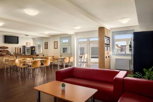 a living room with a red couch and a table at Amedia Express Sattledt, Trademark Collection by Wyndham in Sattledt
