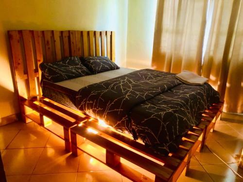 - un lit avec un cadre en bois dans une chambre dans l'établissement Ukali ukalini homes, à Sanya Juu