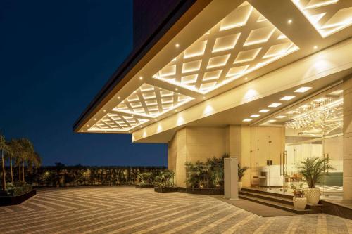 a large building with lights on the side of it at Ramada Encore by Wyndham Amritsar Airport in Amritsar