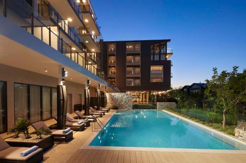 a hotel with a swimming pool and lounge chairs at Hilton Garden Inn Busselton in Busselton