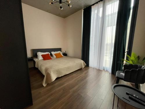 - une chambre avec un lit et une grande fenêtre dans l'établissement Kakheti , Villa Ambassadori Kachreti Golf Resort, à Kachretʼi