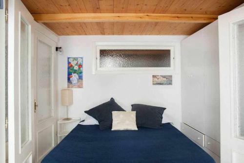 - une chambre avec un lit bleu et une fenêtre dans l'établissement Donna Sara Appartamento in corte Amalfitana, à Amalfi