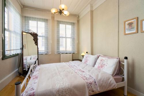 a bedroom with a bed and two windows at Classy Duplex Apartment w Balcony Near Golden Horn in Istanbul