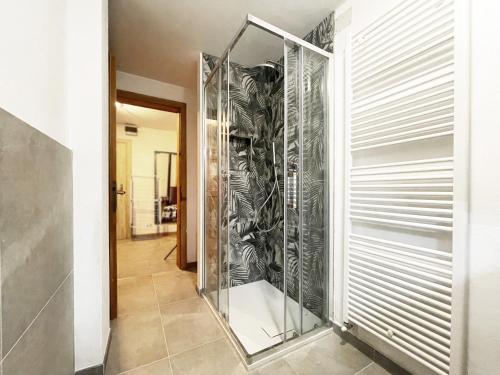Una ducha de cristal a ras de suelo en un pasillo en Appartamenti dolomitici, en Padola