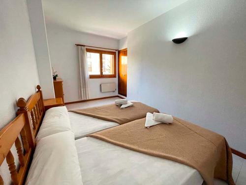 a bedroom with two beds with towels on them at Apartamentos Jaca Ciudadela 3000 in Jaca