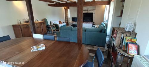 a living room with a wooden table and a couch at La longère en campagne in Louans