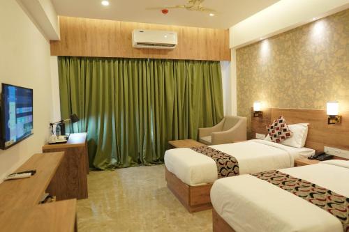 Alwaye的住宿－HOTEL VKJ INN Aluva，酒店客房设有两张床和电视。