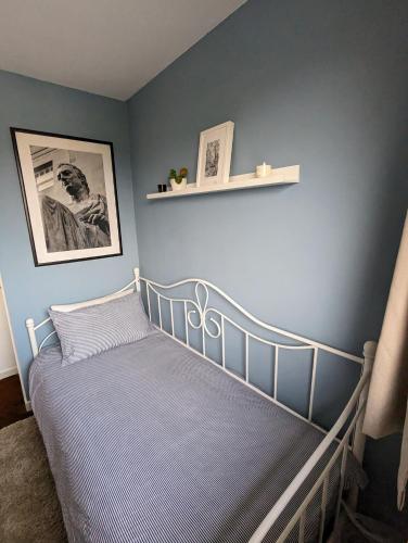 a bedroom with a bed with a blue wall at Single room with Castle view in leafy Edinburgh South in Edinburgh