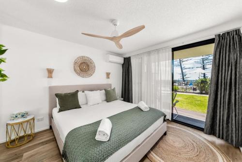 a bedroom with a bed and a large window at Hear the Sea 2 mins from Coolum beach and shops in Coolum Beach